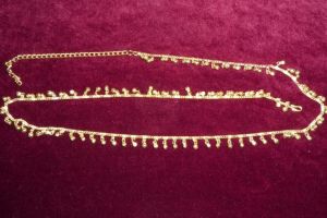 Bauchkette aus goldfarbenem Metall mit Glöckchen